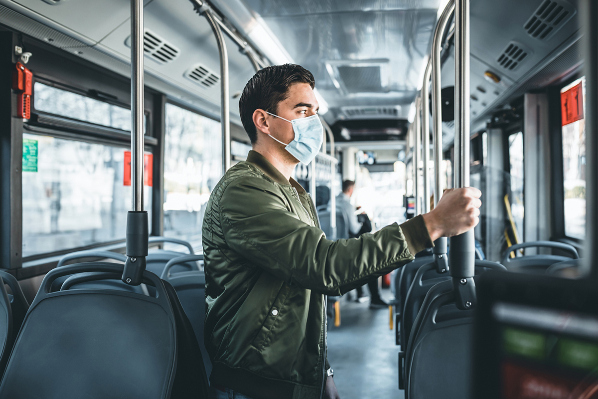 Image of man in bus wearing medical face mask to protect corona virus Covid-19 virus, pollution, face masks traveling during global health emergency, bird flu, respiratory problem, viral pneumonia, SARS, illnesses, quarantine and diseases