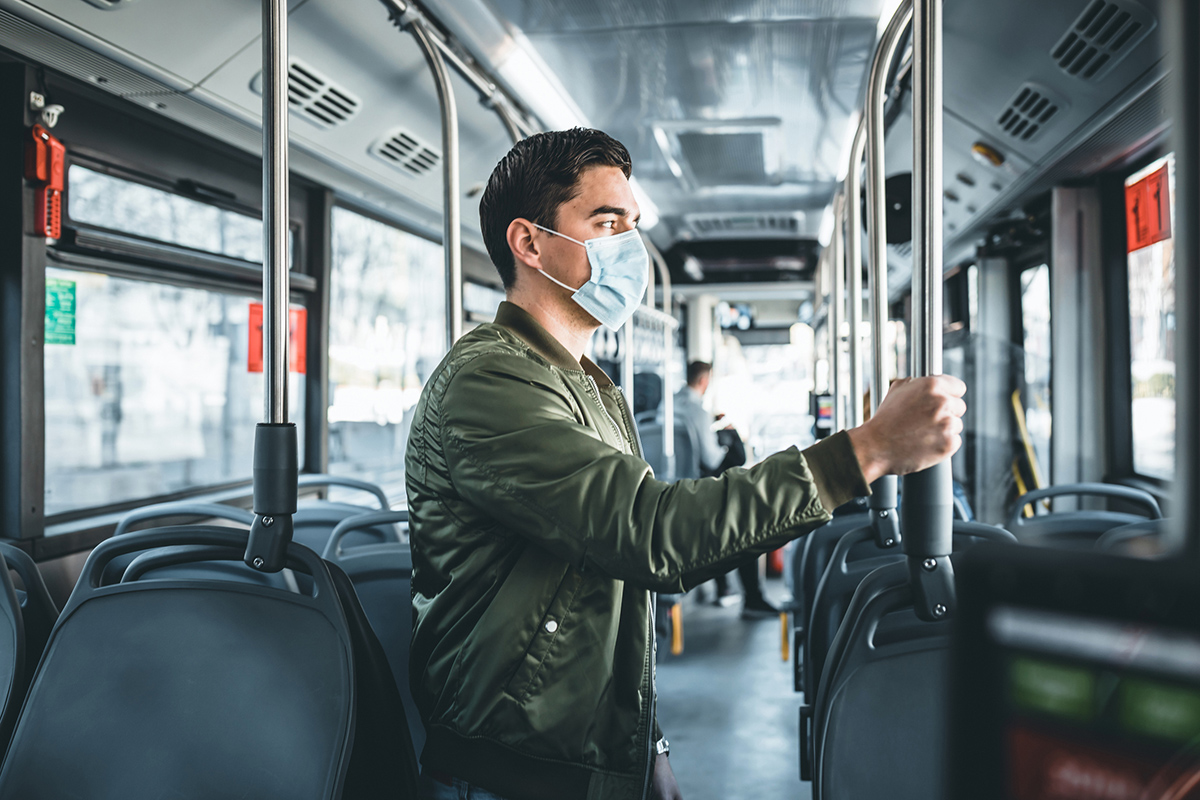 Image of  man in bus wearing medical face mask to protect corona virus Covid-19 virus, pollution, face masks traveling during global health emergency, bird flu, respiratory problem, viral pneumonia, SARS, illnesses, quarantine and diseases