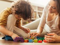 Close up of a young woman and her son playing with colourful blocks